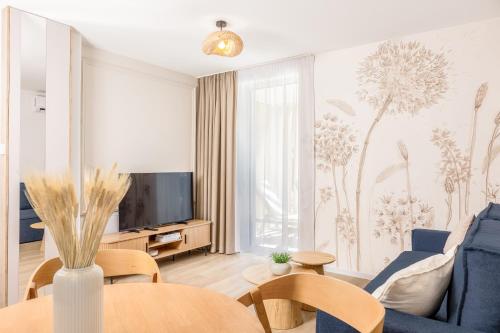 a living room with a blue couch and a tv at Baltic Season Spa Apartments in Grzybowo