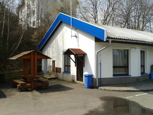 a small white building with a blue roof at ČS Robin Oil Kašperské Hory in Kašperské Hory