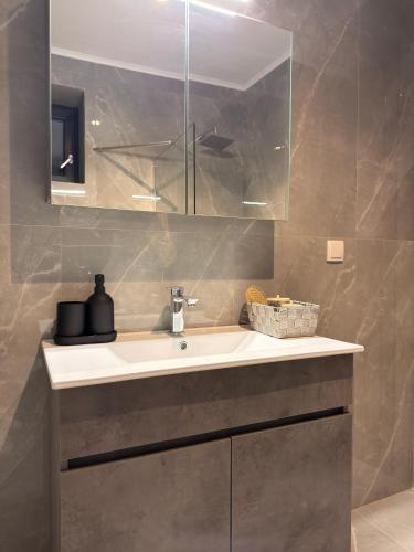 a bathroom with a sink and a mirror at Royal Vinea Suites in Elevtheraí