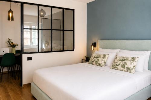 a bedroom with a white bed and a window at Casa Botanica - Boutique Apartment nel centro di Alba in Alba