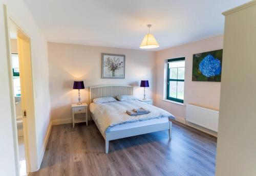 a bedroom with a bed and two lamps in it at Old Rectory House - Waterville in Waterville