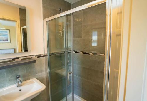 a bathroom with a glass shower and a sink at Old Rectory House - Waterville in Waterville