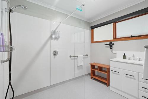 a white bathroom with a shower and a sink at Wildlife, Waves Getaway in Acton Park