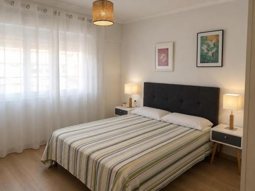 a bedroom with a bed with two night stands and two lamps at Casa Candola in Noya