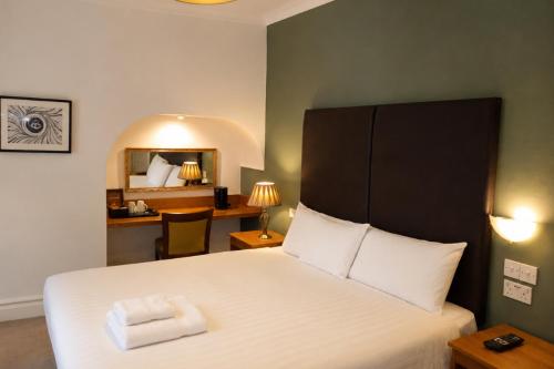 a bedroom with a bed with two towels on it at Wakefield Limes Lodge in Wakefield