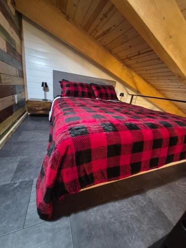 a red and black plaid bed in a room at Cozy Christmas Cabin in North Pole