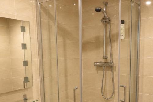 a shower with a glass door in a bathroom at Wakefield Limes Lodge in Wakefield