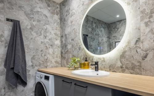 a bathroom with a sink and a mirror at Barberry Apartments in Raadi