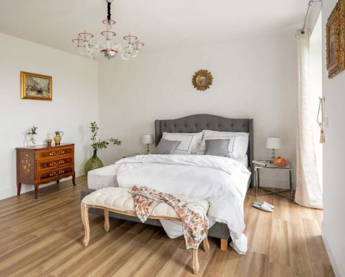 a bedroom with a large bed and a chandelier at Secluded Vineyard Villa With Panoramic Views in Kojsko