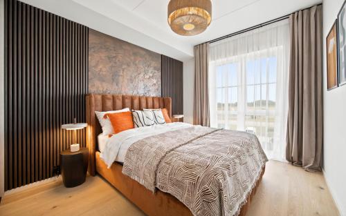 a bedroom with a bed and a large window at Barberry Apartments in Raadi