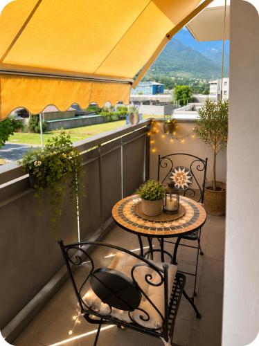 a table and two chairs on a balcony with a view at Valtellinaresidence in Sondrio