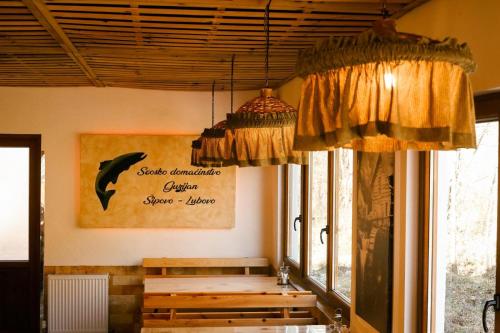 a dining room with a table and a whale sign on the wall at GUZIJAN seosko domaćinstvo in Šipovo