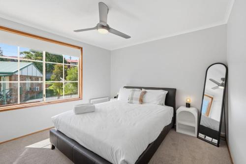 a bedroom with a large bed and a window at Cosy Unit Near MONA in Claremont
