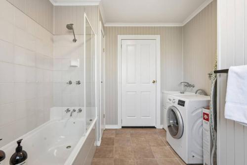 a bathroom with a washing machine and a washer at Cosy Unit Near MONA in Claremont
