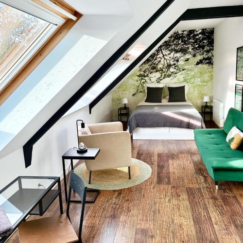 a loft bedroom with a bed and a couch at La Breizhidence in Combourg