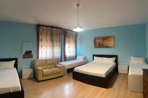 a room with two beds and a couch and a chair at Venice Night B13 in Mestre