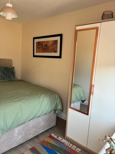 a bedroom with a bed and a mirror at Griffin Lodge in Warwick