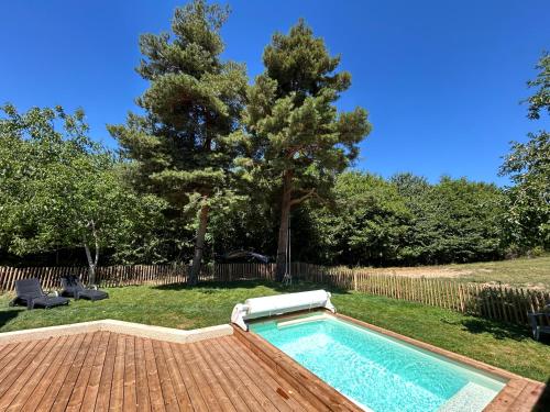 a swimming pool in a yard with a tree at Gîte Alice Piscine privée in Hauterives