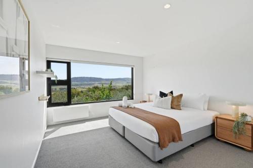 a white bedroom with a large bed and a window at Richmond Valley Luxe Escape in Richmond