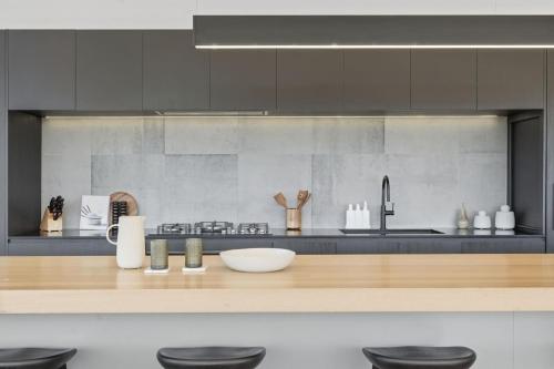 a kitchen with black cabinets and a wooden counter top at Richmond Valley Luxe Escape in Richmond