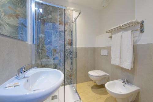 a bathroom with a shower and a sink and a toilet at Hotel Colorado in Rimini