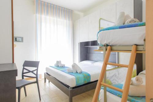 a bedroom with two bunk beds and a chair at Hotel Colorado in Rimini