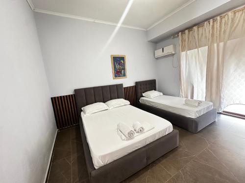 a bedroom with two beds and a window at Almer room 2 in Himare