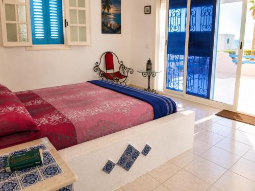 a bedroom with a bed and a table at Villa Jasmin Zarzis in Zarzis