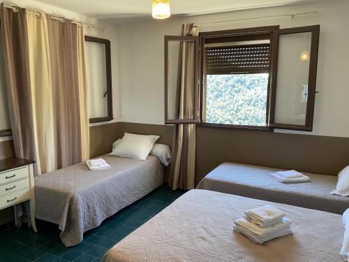 a room with two beds and a window at Hotel U Liccedu in Bustanico