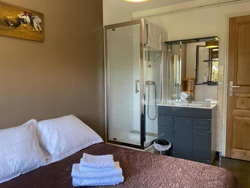 a bathroom with a shower and a bed with towels at Hotel U Liccedu in Bustanico