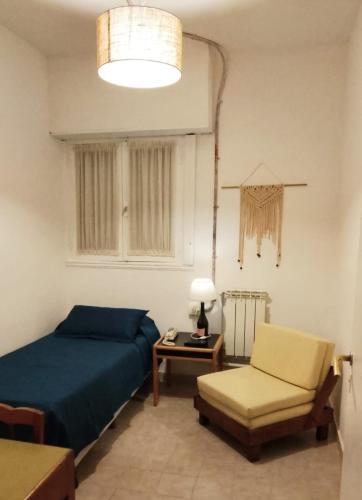 a bedroom with a bed and a chair and a table at Hotel Medina y Mar BnB in Mar del Plata