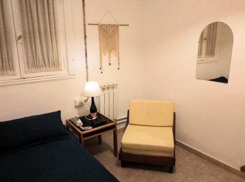 a living room with a bed and a chair at Hotel Medina y Mar BnB in Mar del Plata