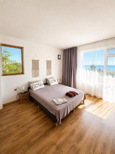 a bedroom with a large bed and a large window at Villa Smokinya in Sozopol