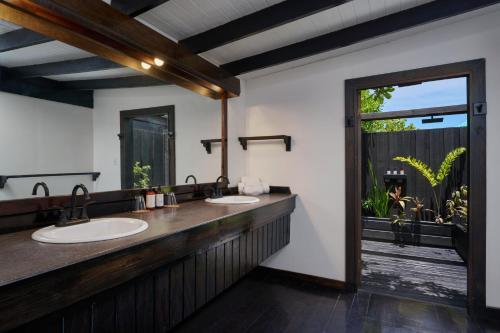 a bathroom with two sinks and a large window at Keyonna Beach - All Inclusive - Couples Only in Saint Johnʼs