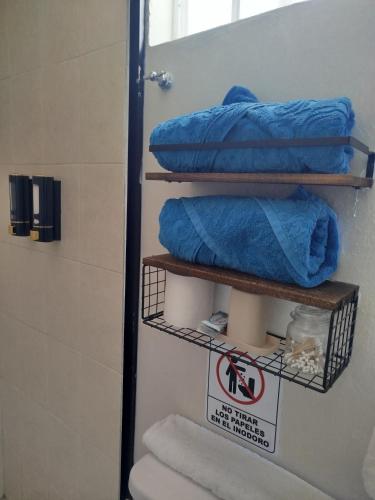 a bathroom with a toilet and some towels and a sign at Tlaxcala Apartment # 5 in Ciudad Obregón