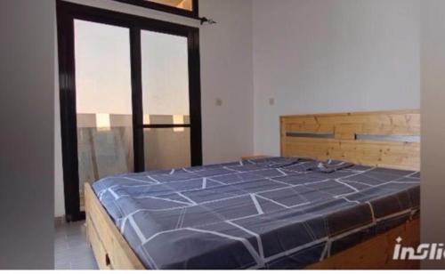 a large blue bed in a room with windows at la perle de ngaparou in Saly Portudal