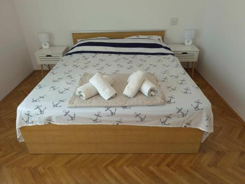 a bedroom with a bed with two pillows on it at Apartmani Božica in Jadranovo