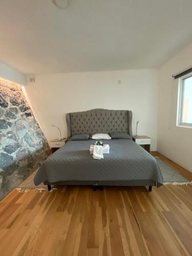 a bedroom with a bed and a wooden floor at Loft with Pool, Gym & A/C Suite in Querétaro