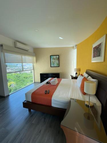 a large bedroom with a large bed and a window at Penthouse with Pool, Gym & A/C in Querétaro