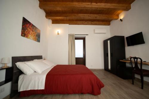 a bedroom with a red and white bed and a desk at CASALE DILETTOSO Etna Relais in Randazzo