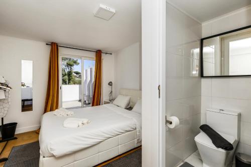 a small bedroom with a bed and a mirror at Maison Azur Oeiras Beach in Oeiras