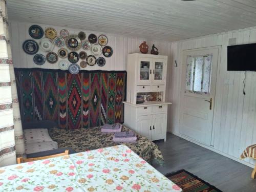 a room with plates on the wall and a table at Бабусині маєтки in Lazeshchyna