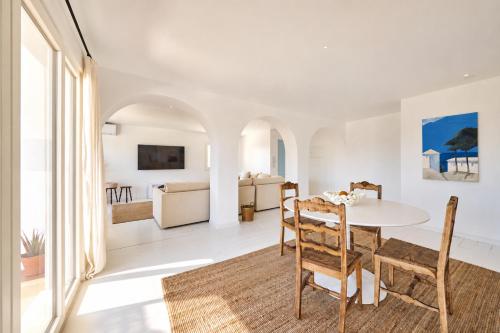 a white living room with a table and chairs at Casa Branca - Caparica in Charneca