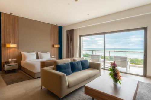 a hotel room with a couch and a bed and a window at Zephyr Mazagan in El Jadida