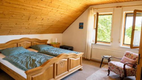 a bedroom with a large wooden bed and a chair at Urlaub mit Hund auf dem Bauernhof Hofswald in Euscheid