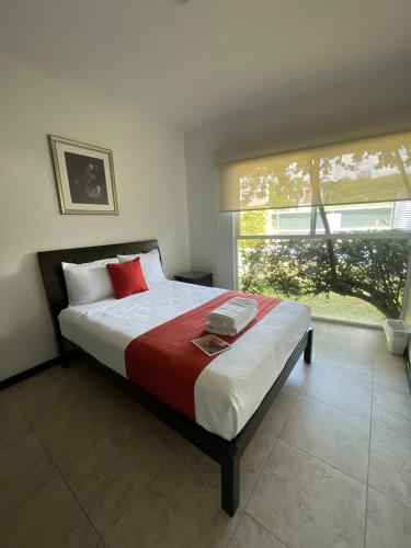 a bedroom with a bed and a large window at Apartment with Pool, Gym & A/C in Querétaro