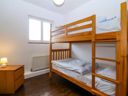 a bedroom with two bunk beds and a desk at Faraway in Rhosneigr