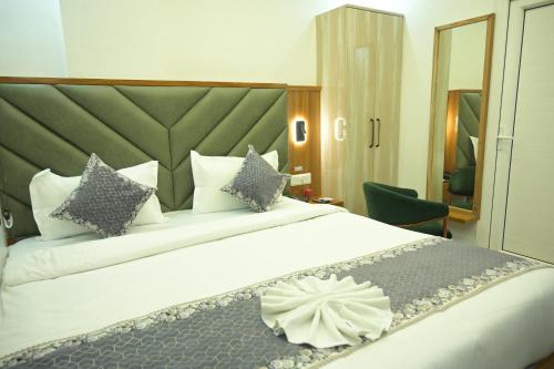 a bedroom with a large white bed with pillows at Hotel Surya Inn in Khagaul