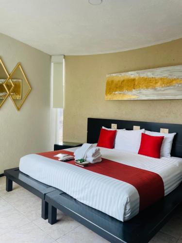 a bedroom with a large bed with red pillows at Apartment with Pool, Gym & A/C Suite in Querétaro