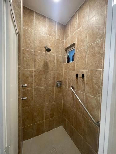 a bathroom with a shower with a glass door at Apartment with Pool, Gym & A/C Suite in Querétaro